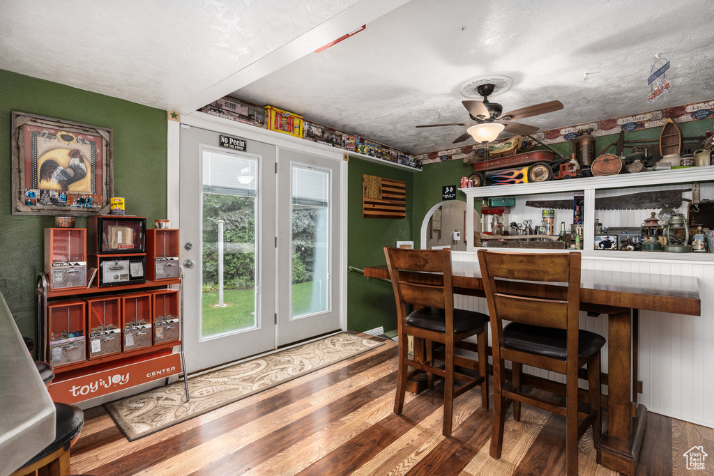 Dining area featuring a dry bar, wood finished floors, and a ceiling fan