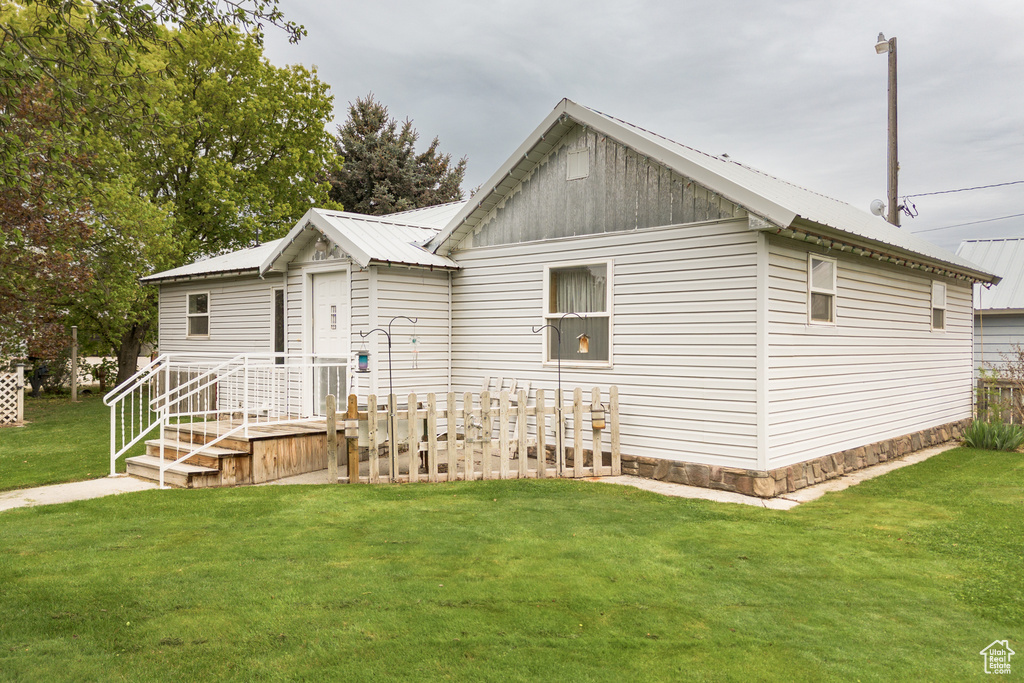 View of front of home featuring a front lawn and metal roof