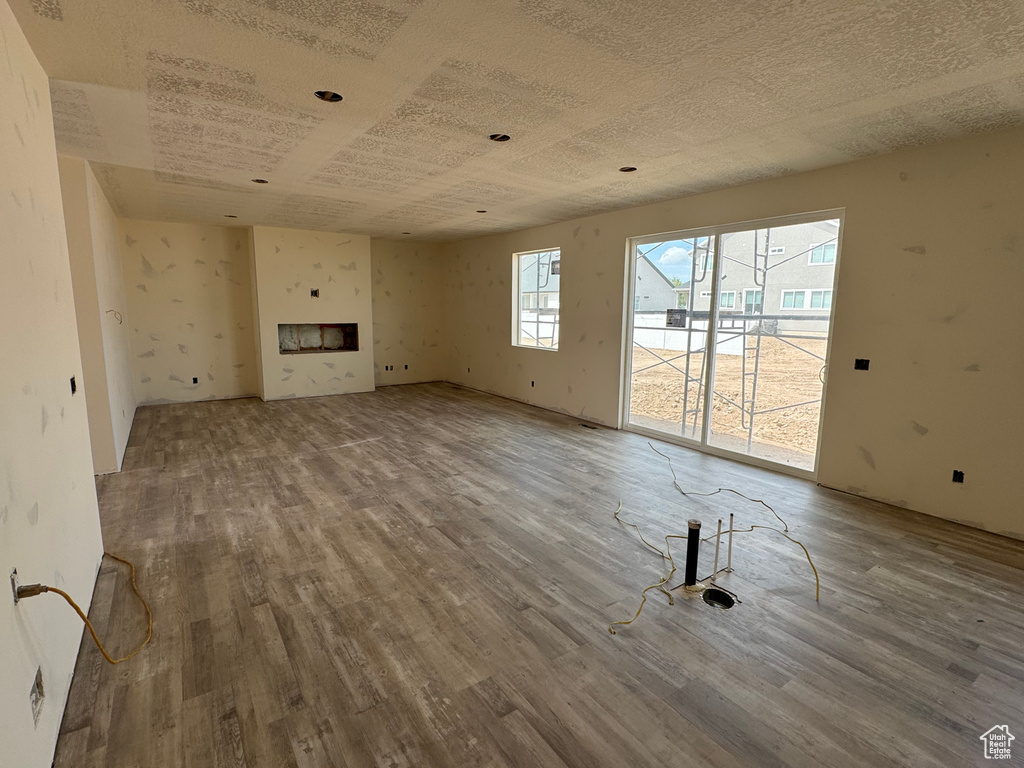Unfurnished living room with wood finished floors and a fireplace