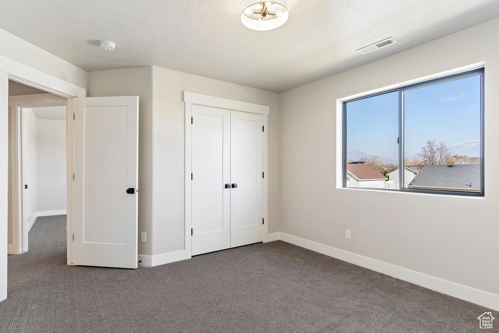 Unfurnished bedroom with carpet, baseboards, and a closet