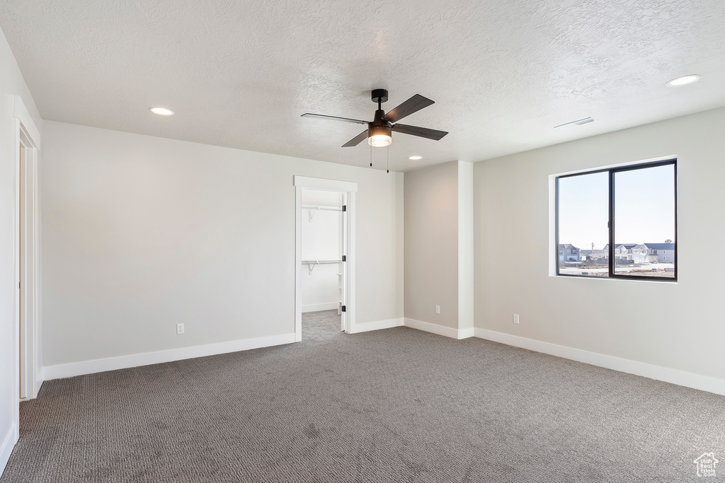 Unfurnished bedroom with a textured ceiling, carpet floors, recessed lighting, baseboards, and a ceiling fan