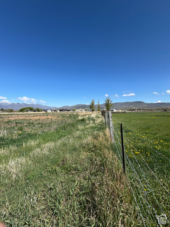 View of yard featuring a view of countryside, fence, and a mountain view