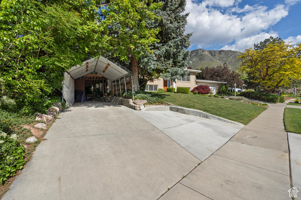 View of front of house with a front yard and a mountain view