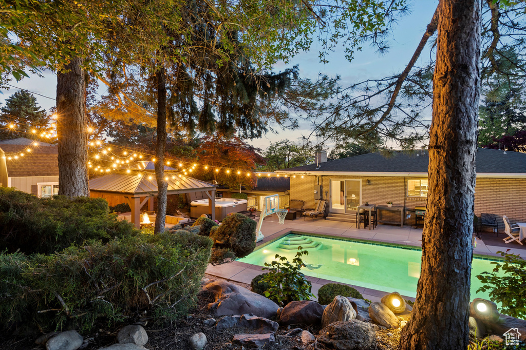 Outdoor pool with a gazebo and a patio area