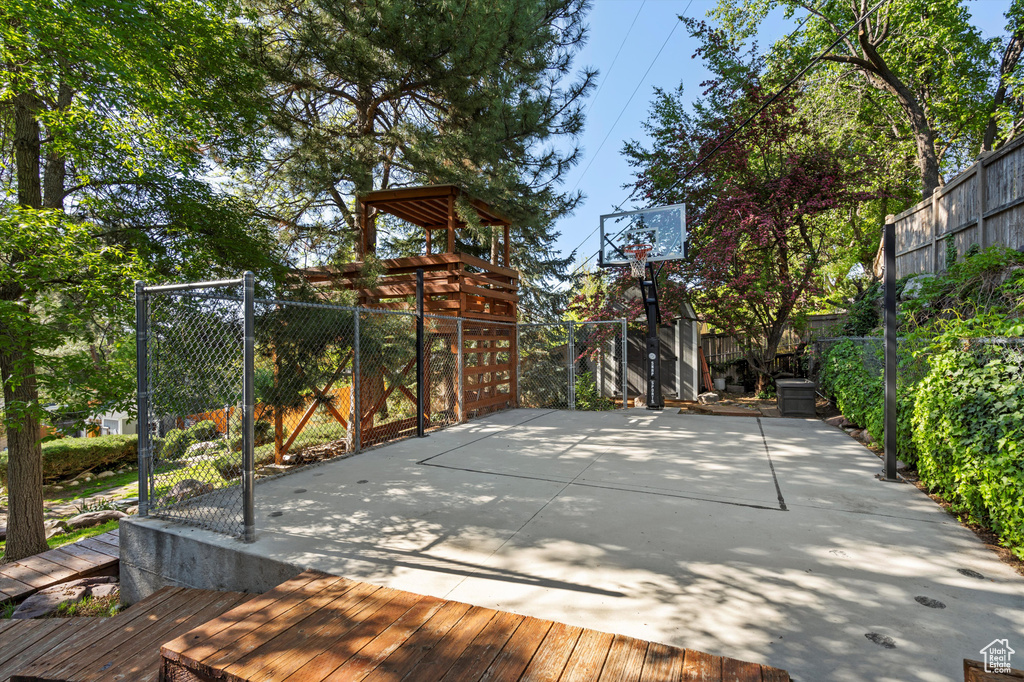 View of sport court featuring basketball hoop and fence