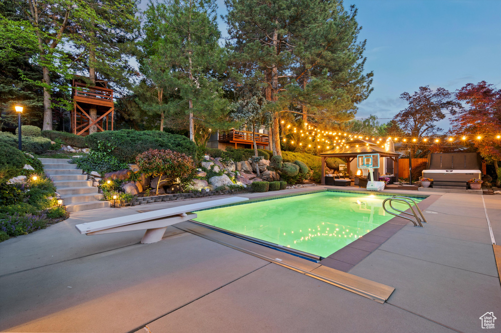 Outdoor pool with stairway, a diving board, and a patio area