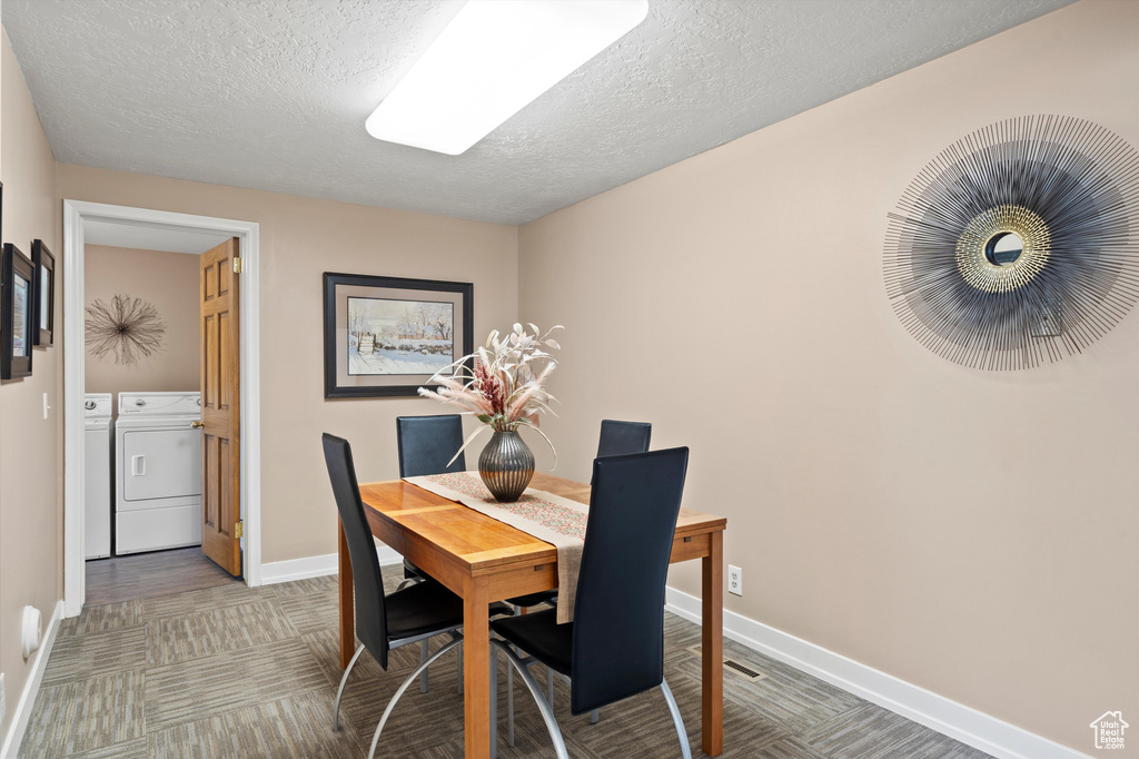 Dining room featuring independent washer and dryer, baseboards, and a textured ceiling