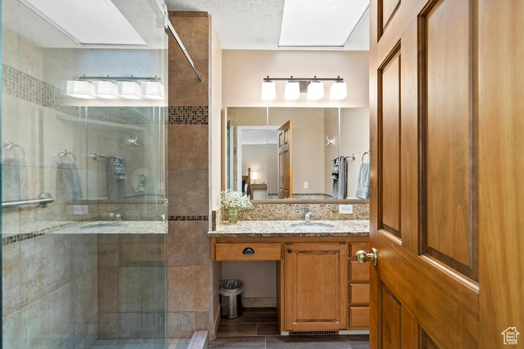 Full bath featuring a stall shower and vanity