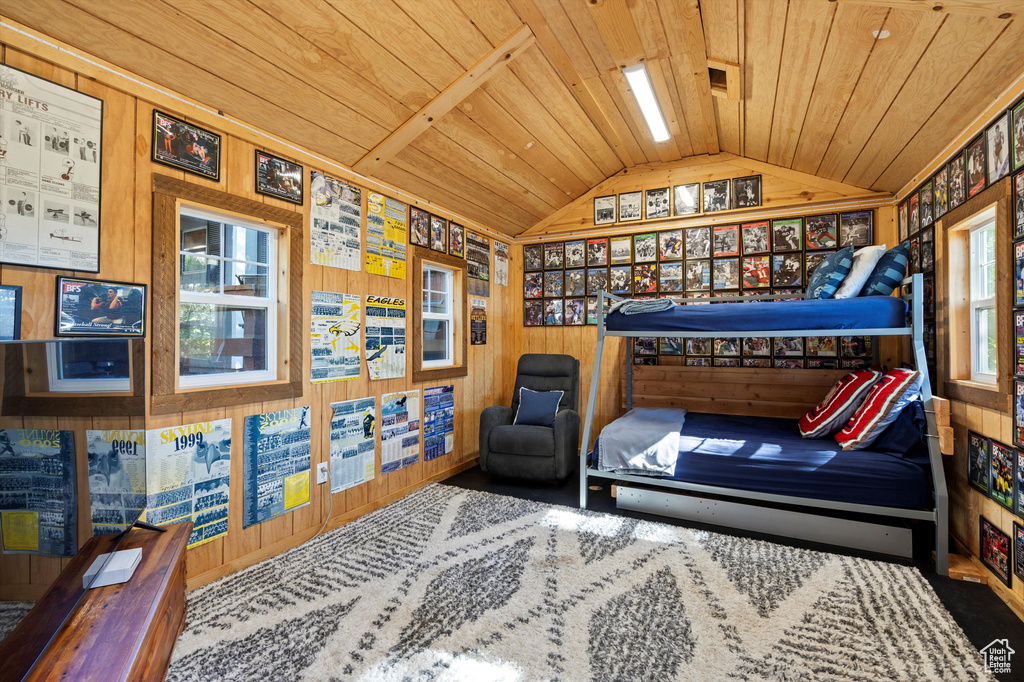Bedroom featuring lofted ceiling, wooden ceiling, wood walls, and carpet