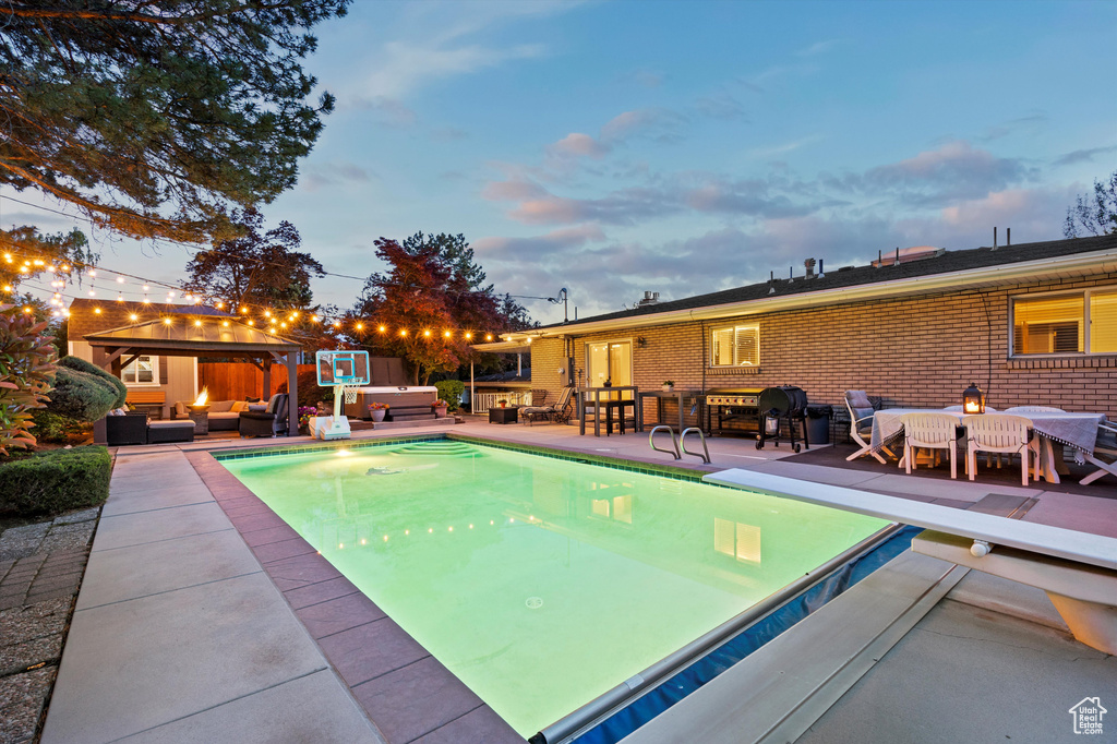 Outdoor pool featuring an outdoor living space, a gazebo, a patio area, and a diving board