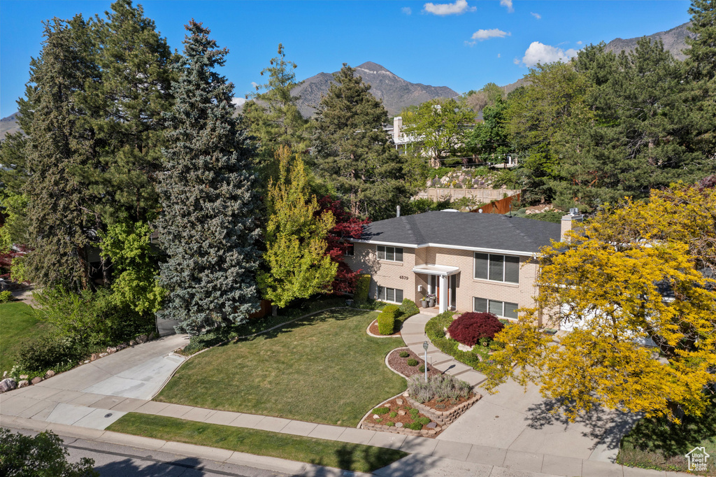 View of front facade with a mountain view and a front yard
