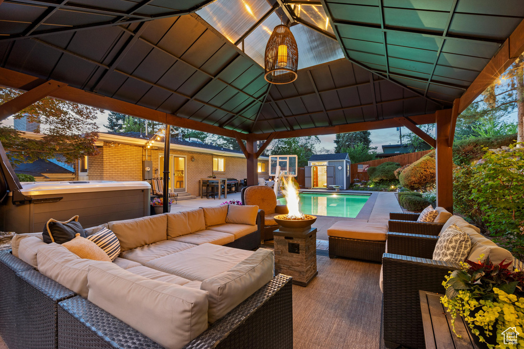View of patio / terrace featuring an outdoor living space, a gazebo, fence, a shed, and an outdoor structure