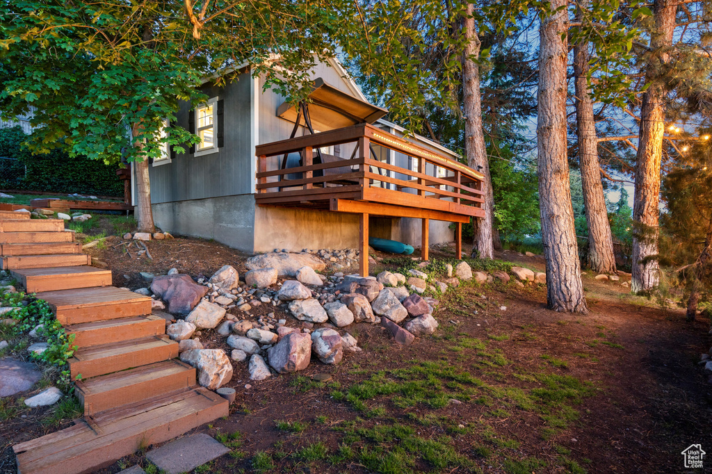 Back of property with stairs and a deck