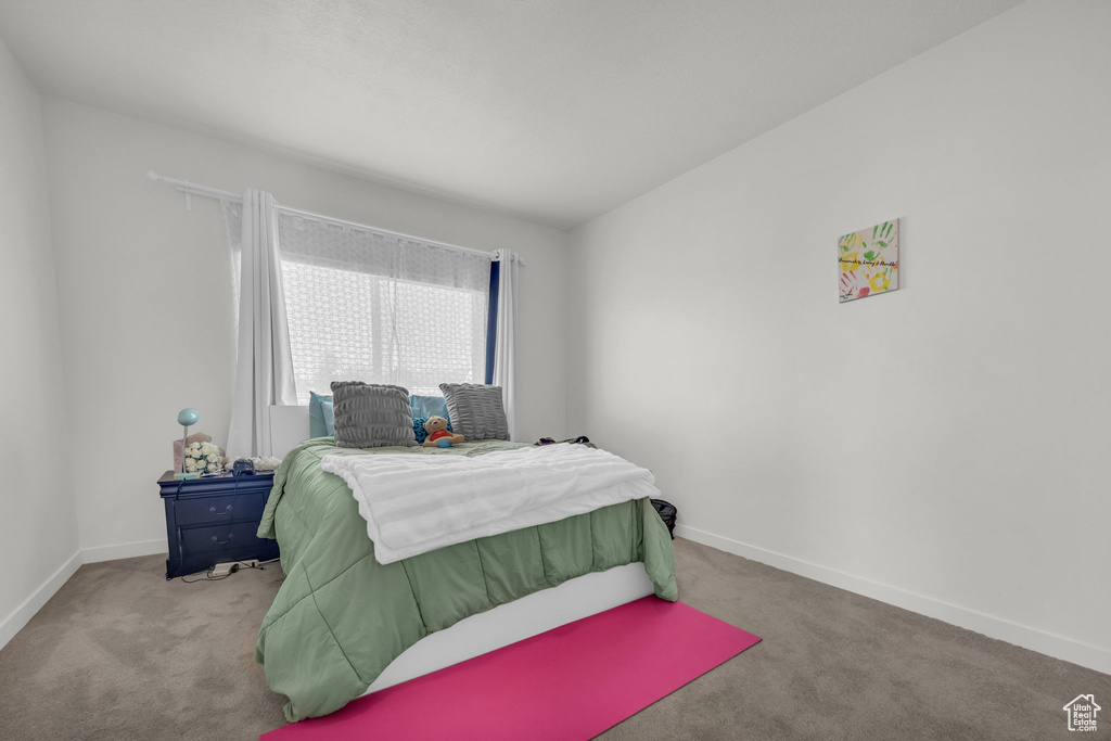 Bedroom featuring carpet and baseboards