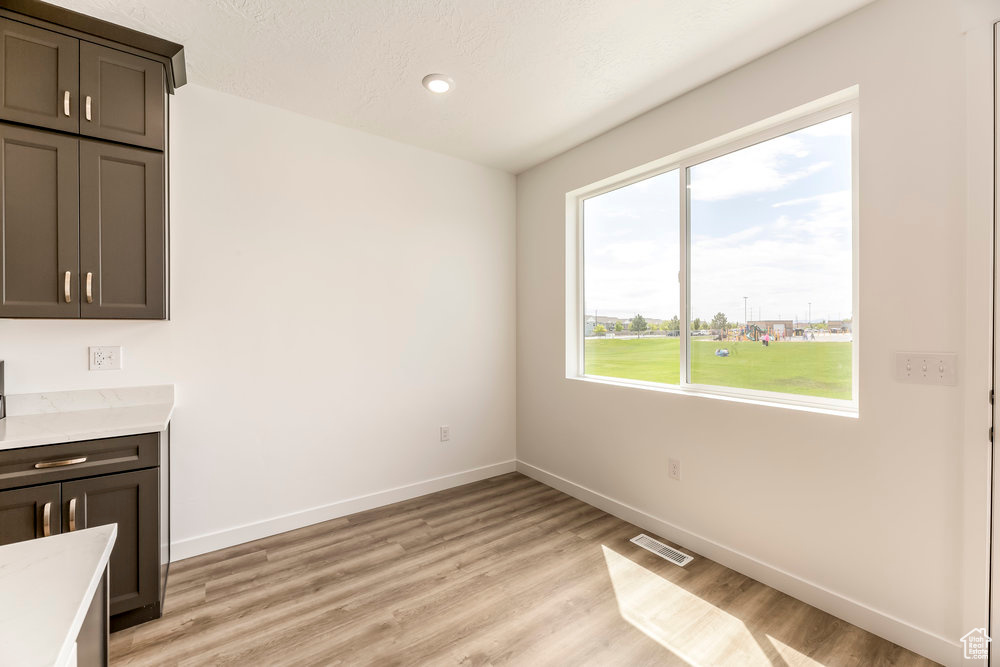 Unfurnished dining area featuring baseboards, light wood-style flooring, and recessed lighting