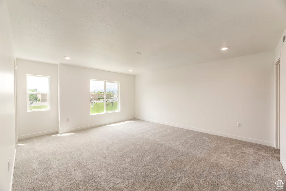 Spare room with light colored carpet, recessed lighting, and baseboards