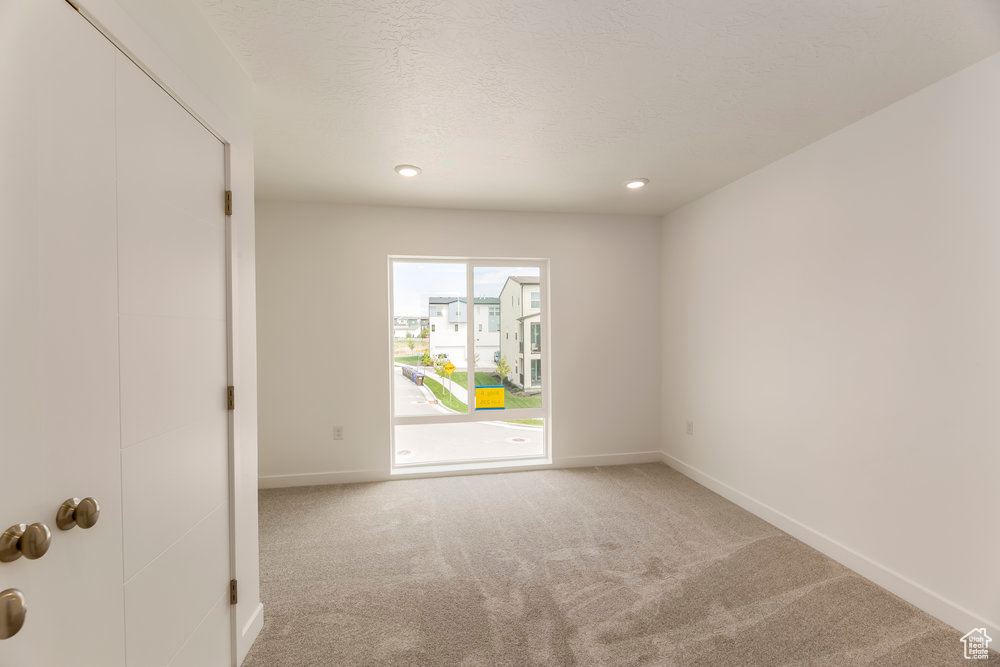 Carpeted spare room featuring baseboards and recessed lighting
