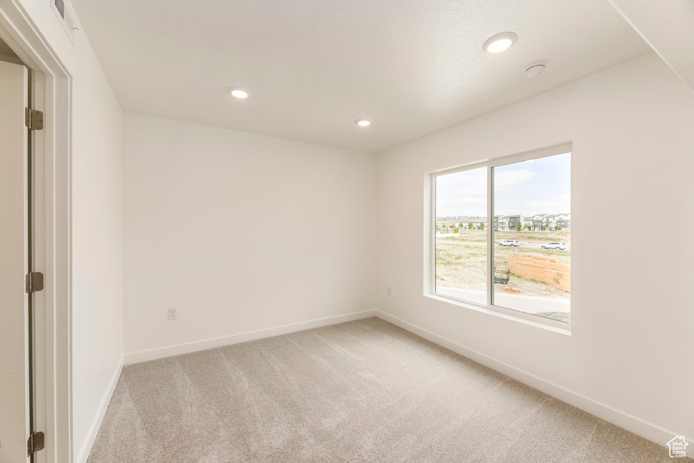 Unfurnished room with light carpet, baseboards, and recessed lighting
