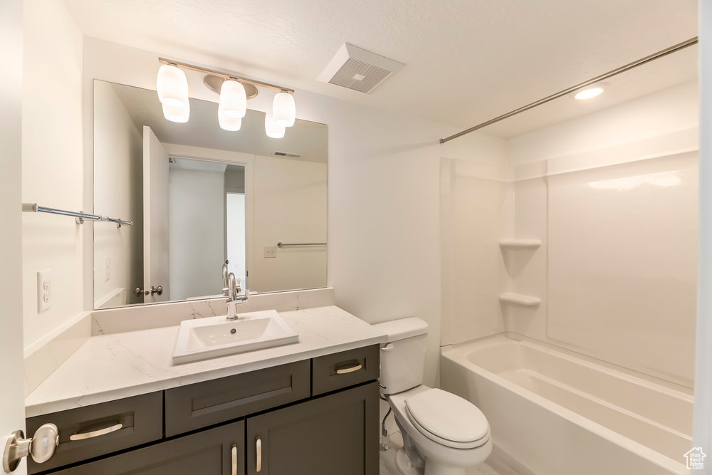 Bathroom featuring toilet, vanity, bathing tub / shower combination, and recessed lighting