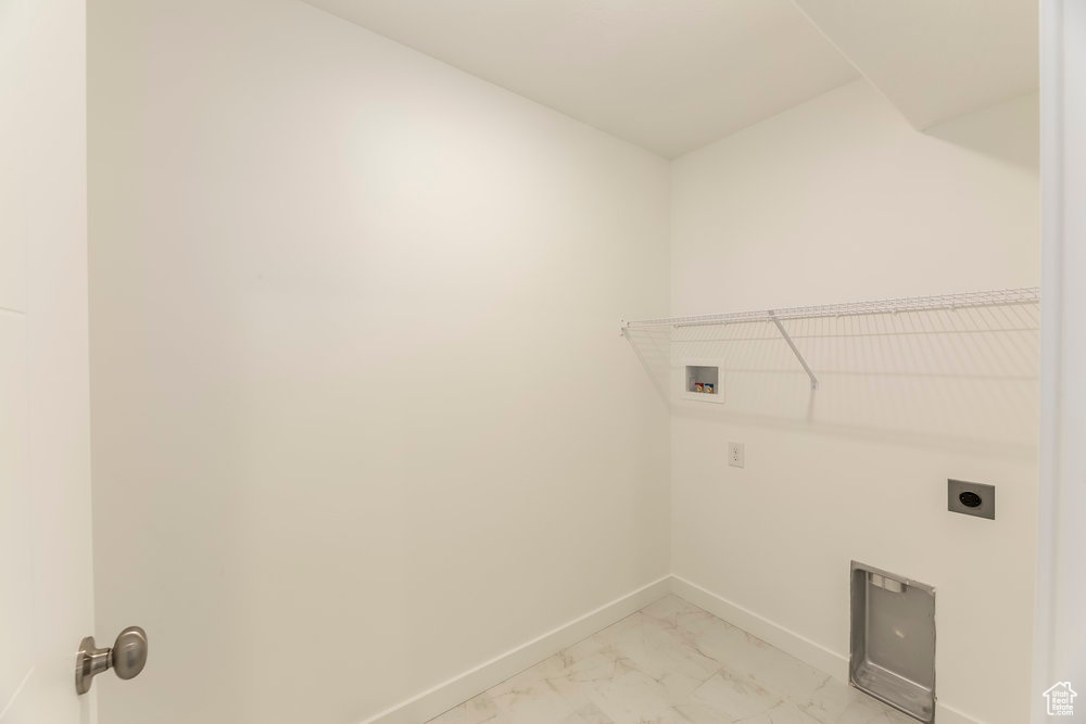 Laundry area featuring electric dryer hookup, hookup for a washing machine, light marble finish flooring, and baseboards