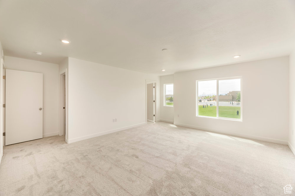 Spare room with light colored carpet, recessed lighting, and baseboards