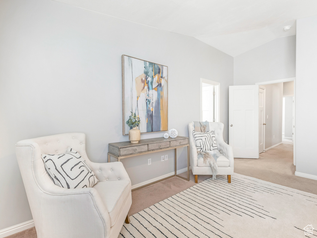 Sitting room with carpet floors, lofted ceiling, and baseboards