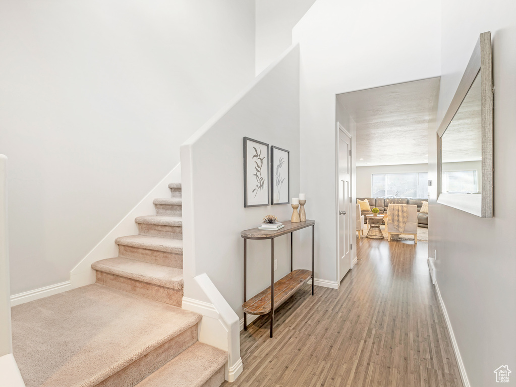 Stairs with wood finished floors and baseboards