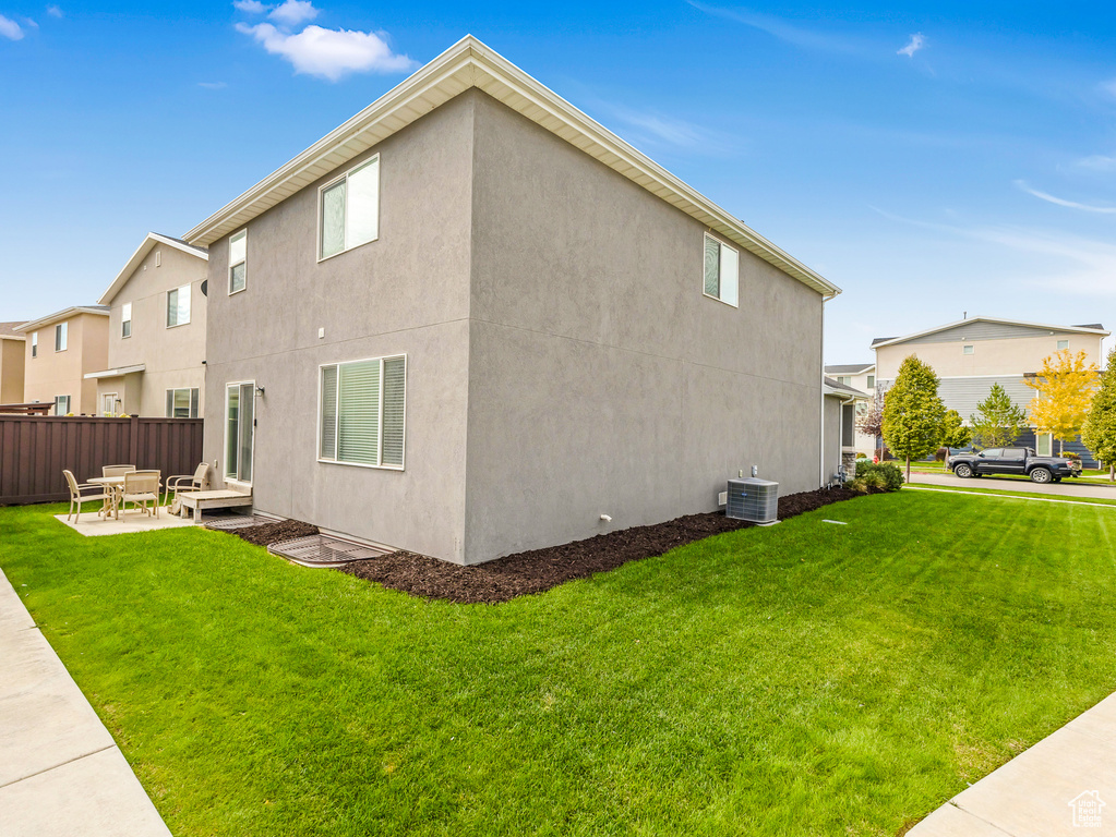 View of side of property featuring central air condition unit, a patio, and stucco siding