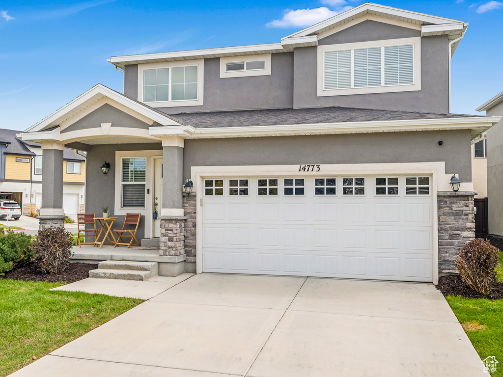 View of front of home featuring a porch, stucco siding, and stone siding