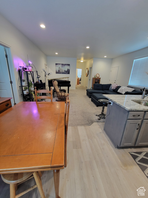 Dining room with light wood-style floors and recessed lighting