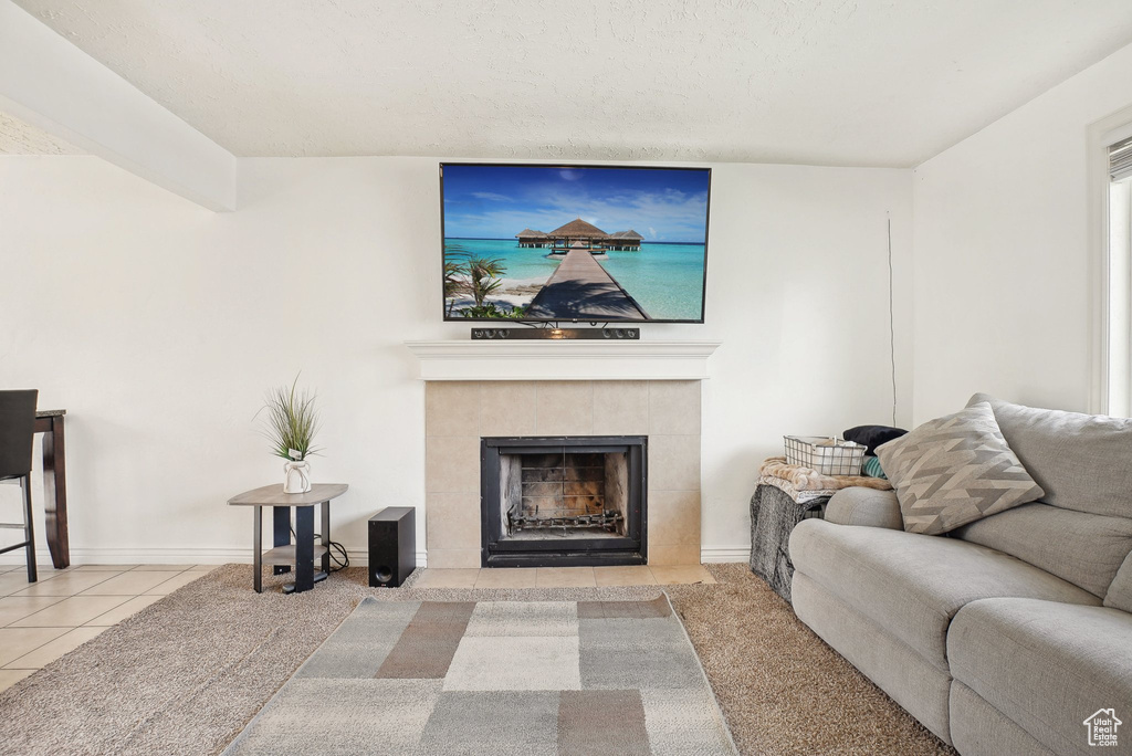 Tiled living area featuring a tile fireplace