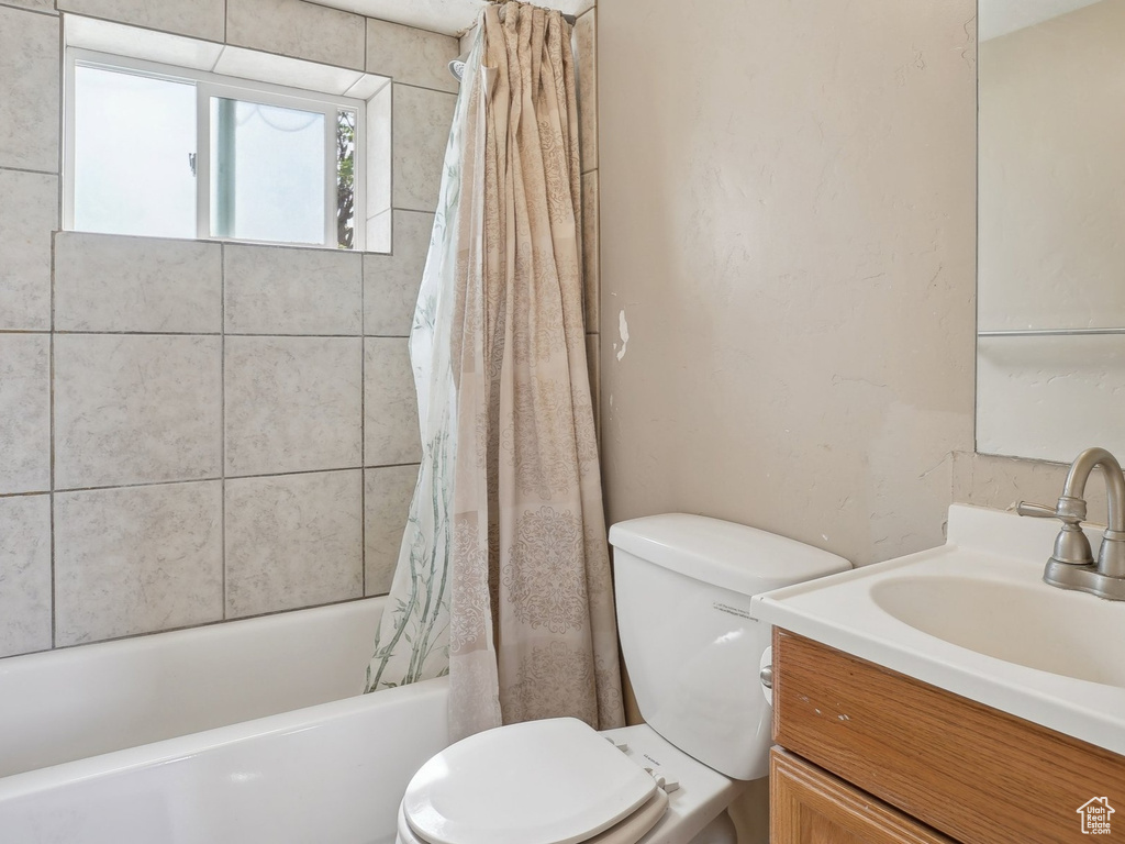 Full bathroom with toilet, shower / tub combo, and vanity