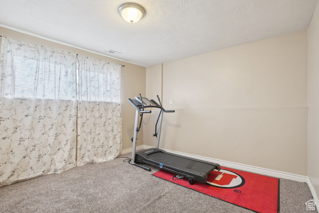 Exercise area with carpet floors and baseboards