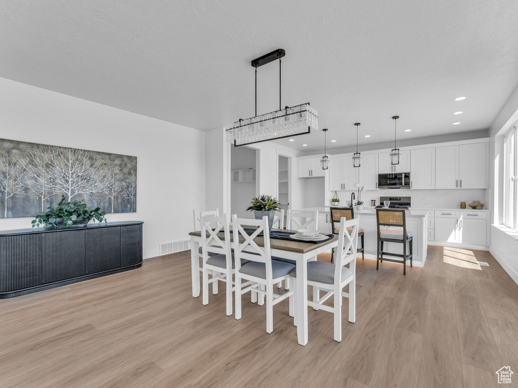 Dining space with light wood finished floors, recessed lighting, and baseboards