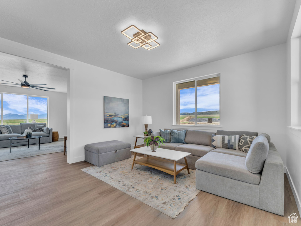 Living area featuring wood finished floors, a ceiling fan, and baseboards