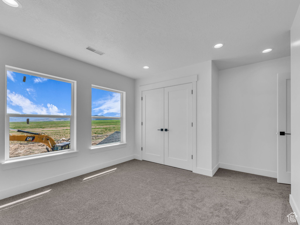Unfurnished bedroom with carpet flooring, recessed lighting, baseboards, and a closet