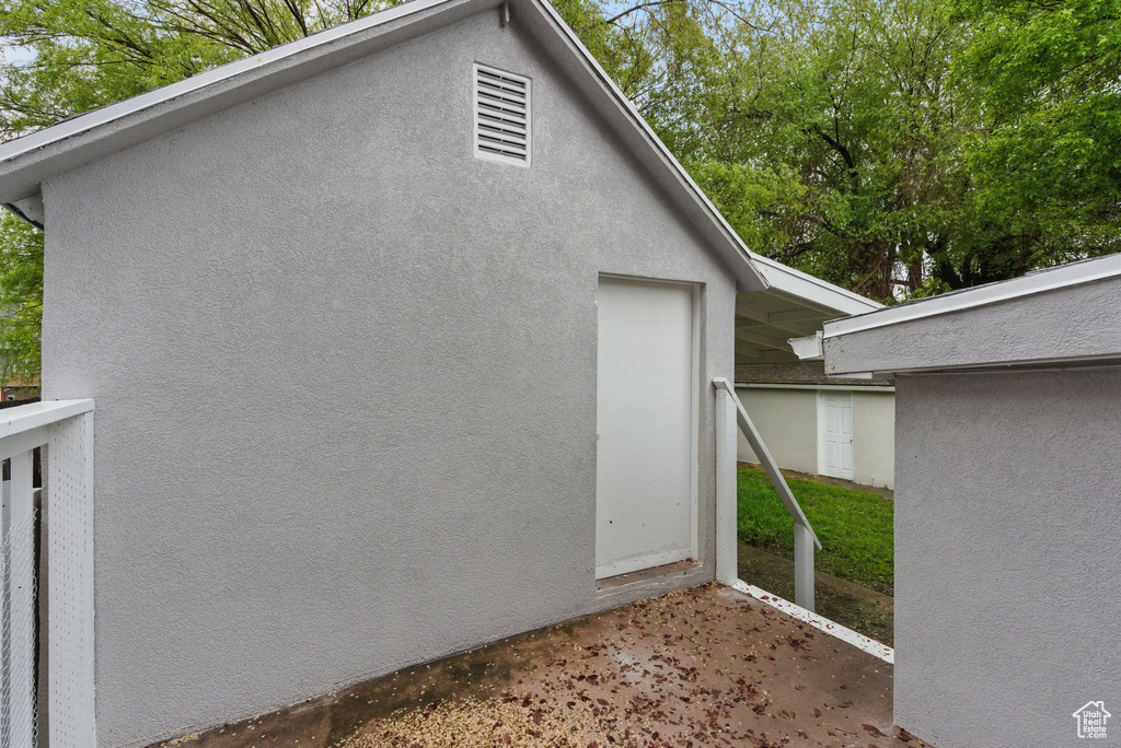 View of side of property with stucco siding and a patio