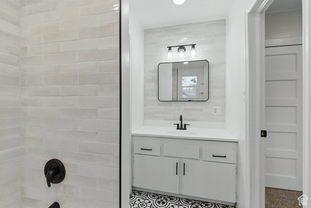 Full bath featuring vanity and washtub / shower combination