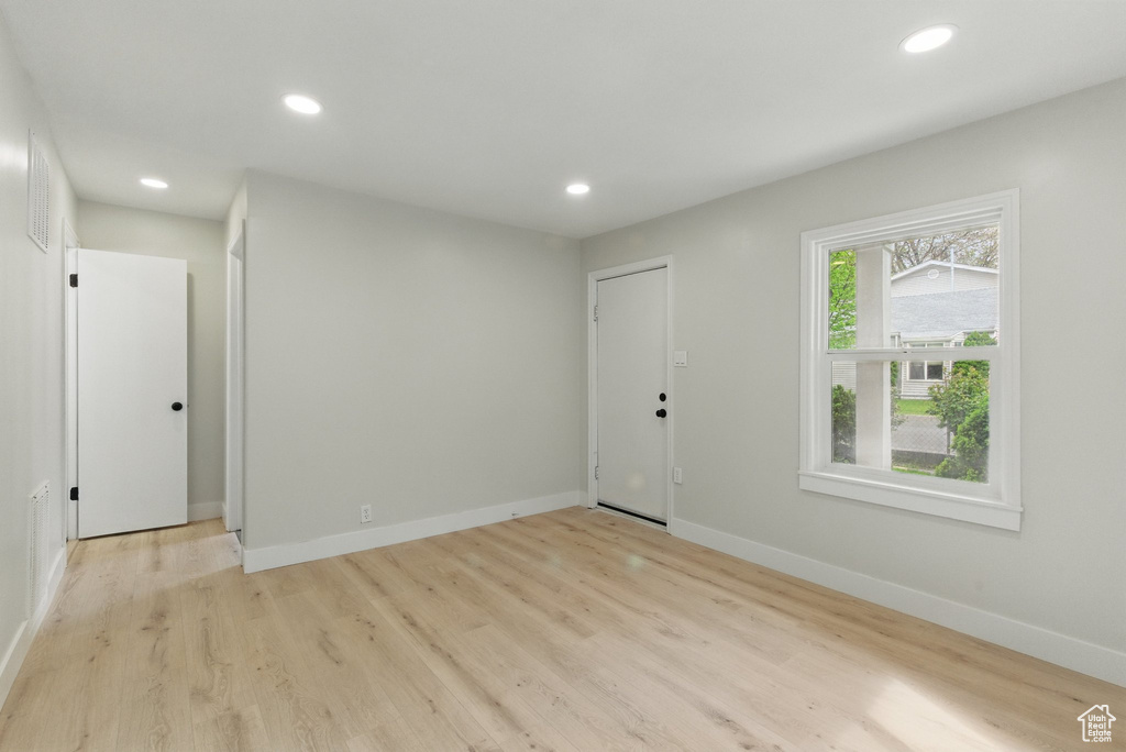 Spare room with baseboards, recessed lighting, and light wood-type flooring
