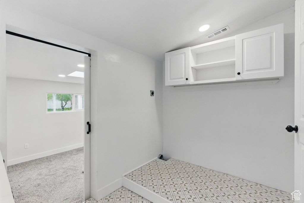 Clothes washing area with cabinet space, electric dryer hookup, baseboards, and recessed lighting