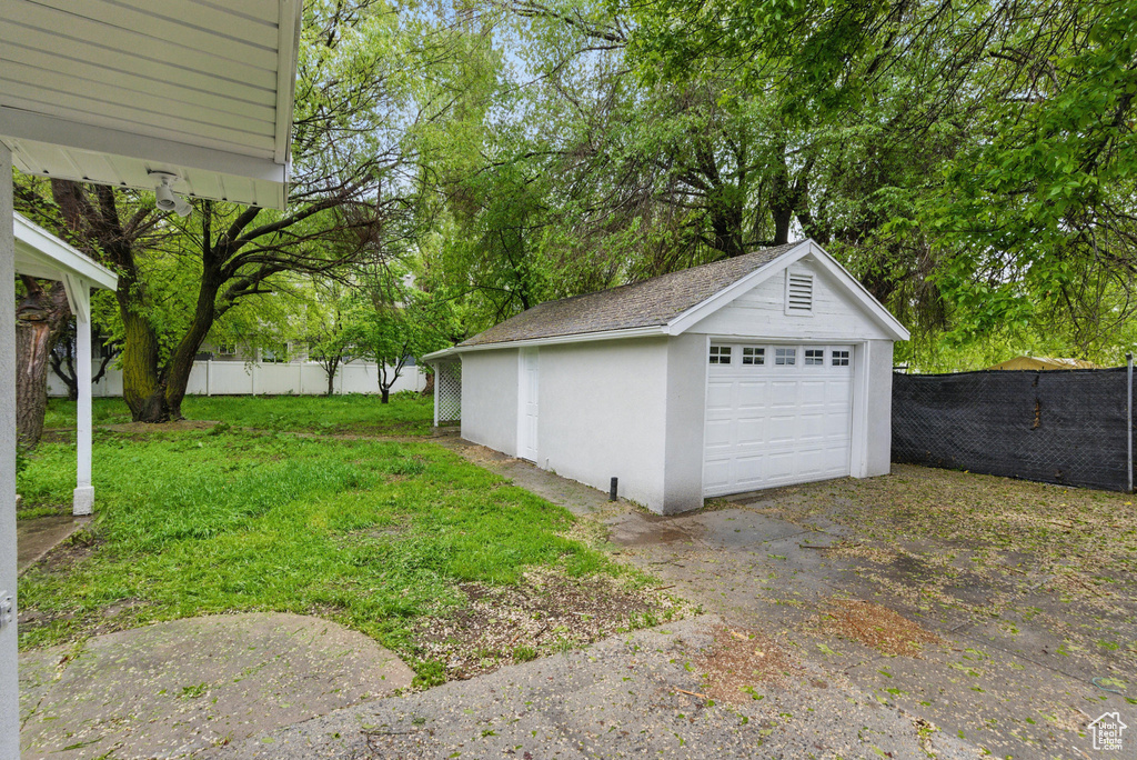 Detached garage featuring view of scattered trees