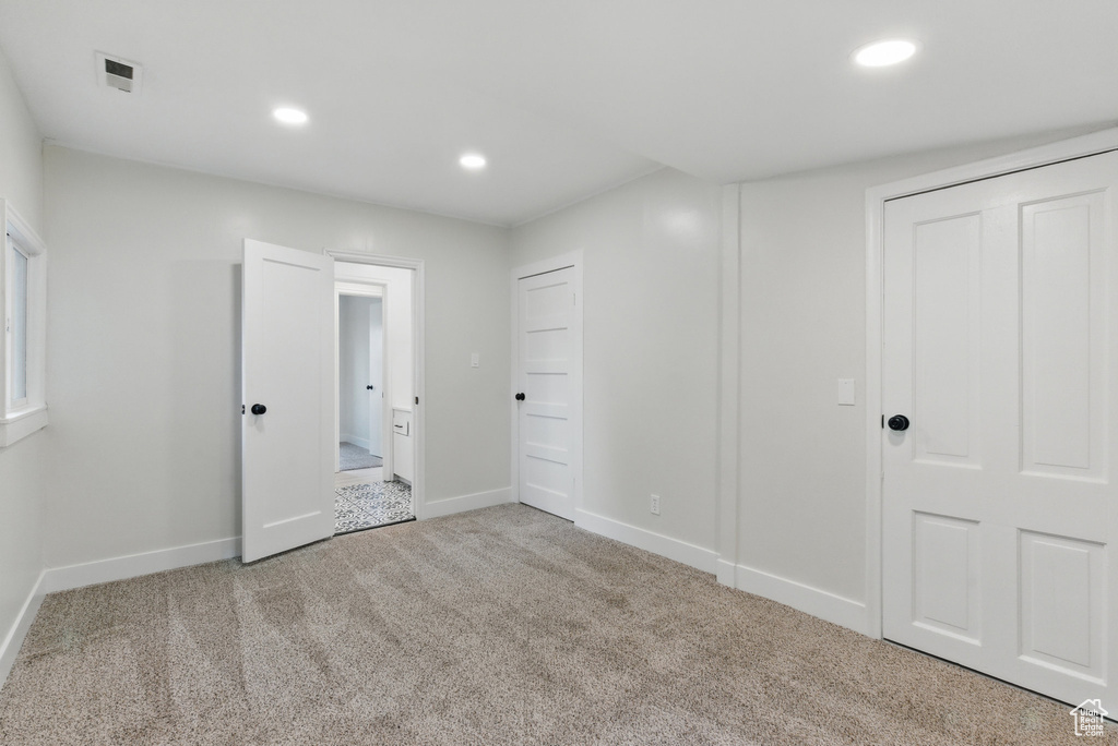 Unfurnished bedroom featuring carpet floors, baseboards, and recessed lighting