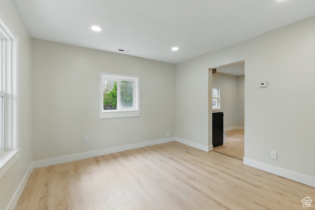 Spare room with healthy amount of natural light, light wood-style flooring, recessed lighting, and baseboards