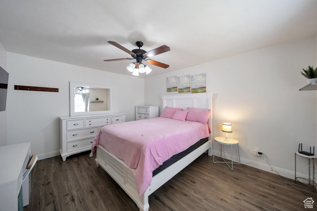 Bedroom featuring dark wood-style flooring, baseboards, and a ceiling fan