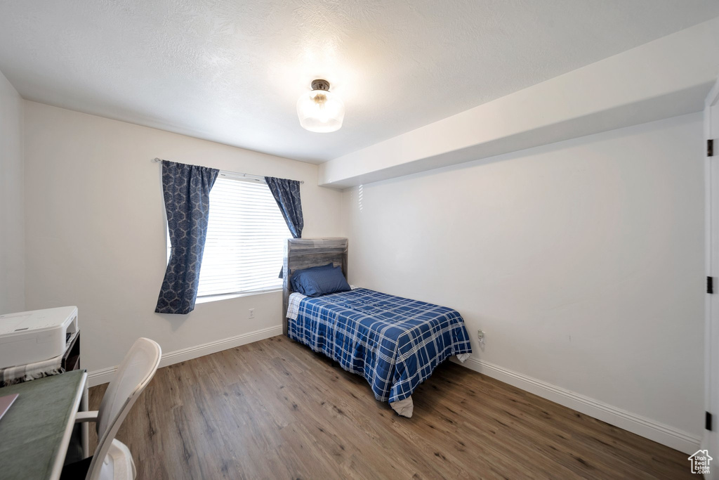 Bedroom with baseboards and wood finished floors