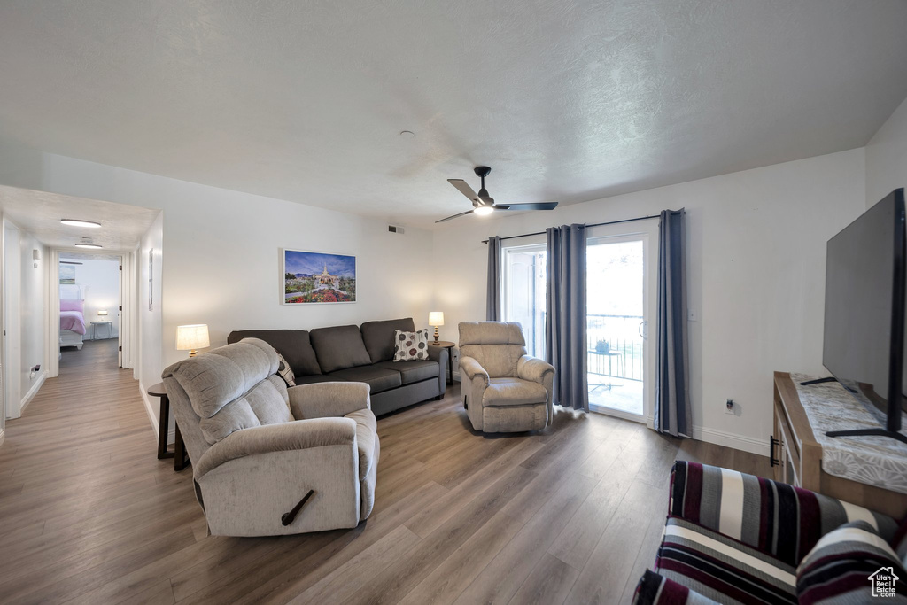 Living room with wood finished floors, baseboards, and a ceiling fan