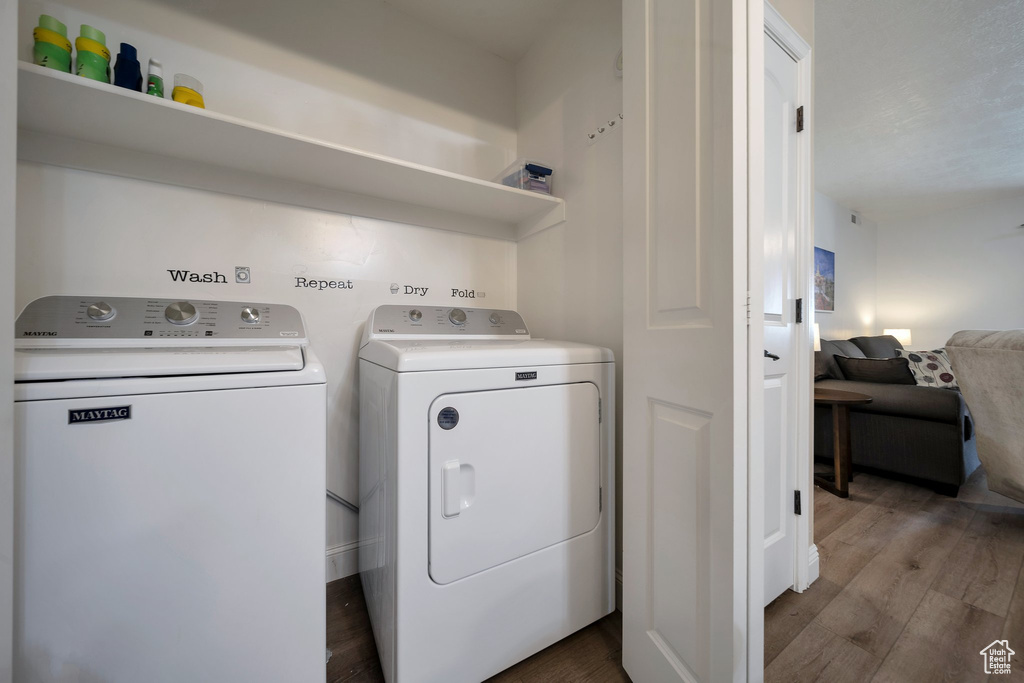 Laundry room featuring washing machine and dryer and wood finished floors