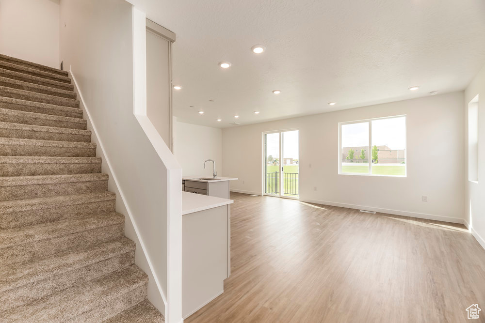 Stairway featuring wood finished floors, recessed lighting, and baseboards
