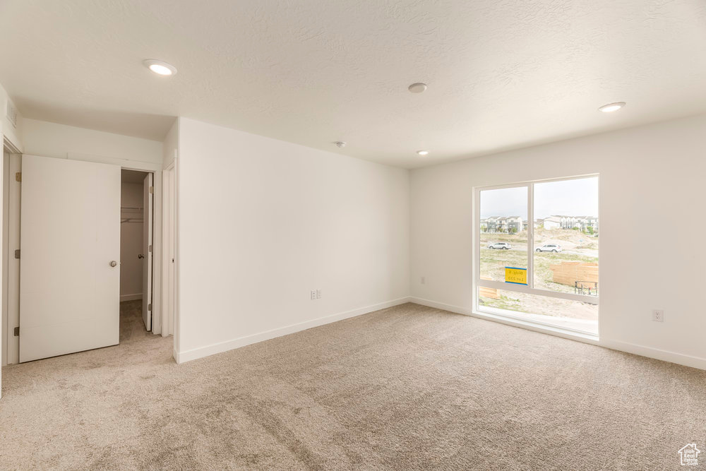 Unfurnished room featuring light carpet, recessed lighting, and baseboards
