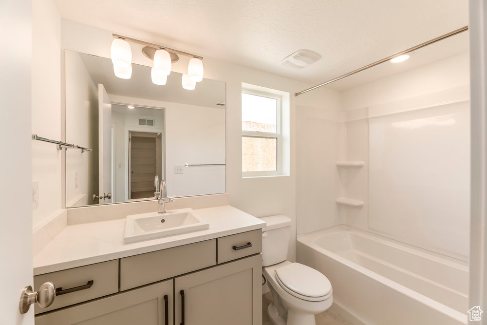 Bathroom with toilet, vanity, and shower / bath combination